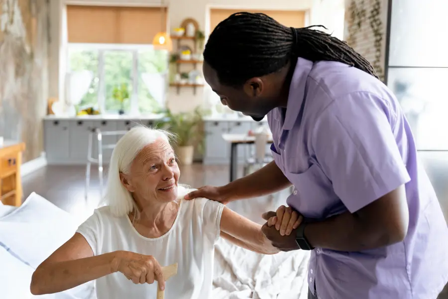 Caregiver-helping-client-out-of-bed